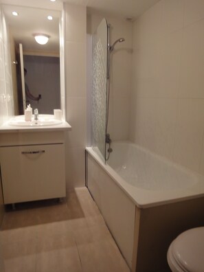 A modern bathroom with a bathtub, a sink, and a toilet. - A WARM AND SPACIOUS HOUSE (Lacanau)