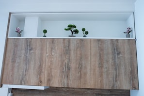 Un mueble de madera con varios estantes, algunos con pequeñas macetas.