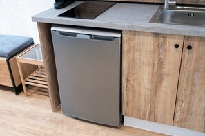 Compact kitchen with dishwasher and sink, featuring a modern design.