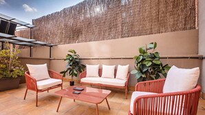 An outdoor patio with wicker furniture, a table, and potted plants. - Sweett | Fira 104 - Two Bedroom Apartment, Sleeps 4 (Barcelona)