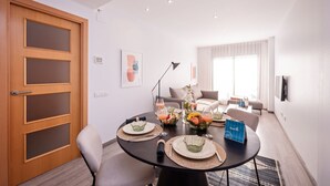 Uma área de jantar moderna com uma mesa redonda, cadeiras e um serviço de buffet.