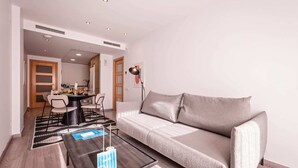 Uma sala de estar moderna com um sofá, uma mesa de centro e um espaço de jantar com cadeiras e uma mesa.