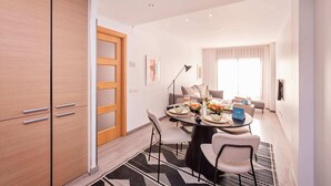 Een moderne eetruimte met een ronde tafel, stoelen en een buffetopstelling.