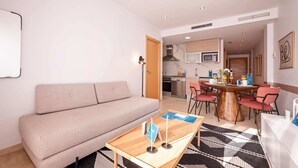 Uma sala de estar moderna com um sofá, uma mesa de centro de madeira e um espaço de jantar com cadeiras e mesa.