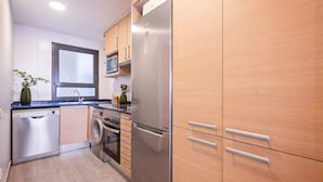 Eine moderne Küche mit Edelstahlgeräten, Holzschränken und einem eingebauten Backofen.