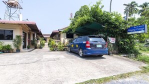 A blue car parked in front of a building with a sign reading "Naiyang Cottage." - OYO 325 Naiyang Cottage (Sa Khu)
