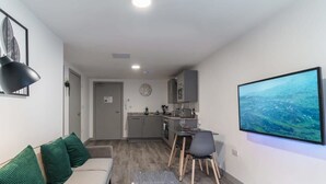 Moderni huoneisto, jossa on olohuone, ruokailutila ja keittiö.