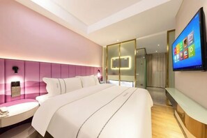 A modern hotel room with a large bed, a bedside table, a TV mounted on the wall, and a glass partition separating the room from the hallway. - Langfeng Capital Hotel Zhongshan (Former Sun Yat-sen · Nanlang Station Branch) (Zhongshan)