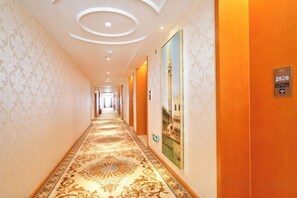 A hotel corridor with a patterned carpet, wall-mounted artwork, and a sign indicating room number 2826. - Vienna Hotel Xiangtan Bantang Bubugao (Xiangtan)