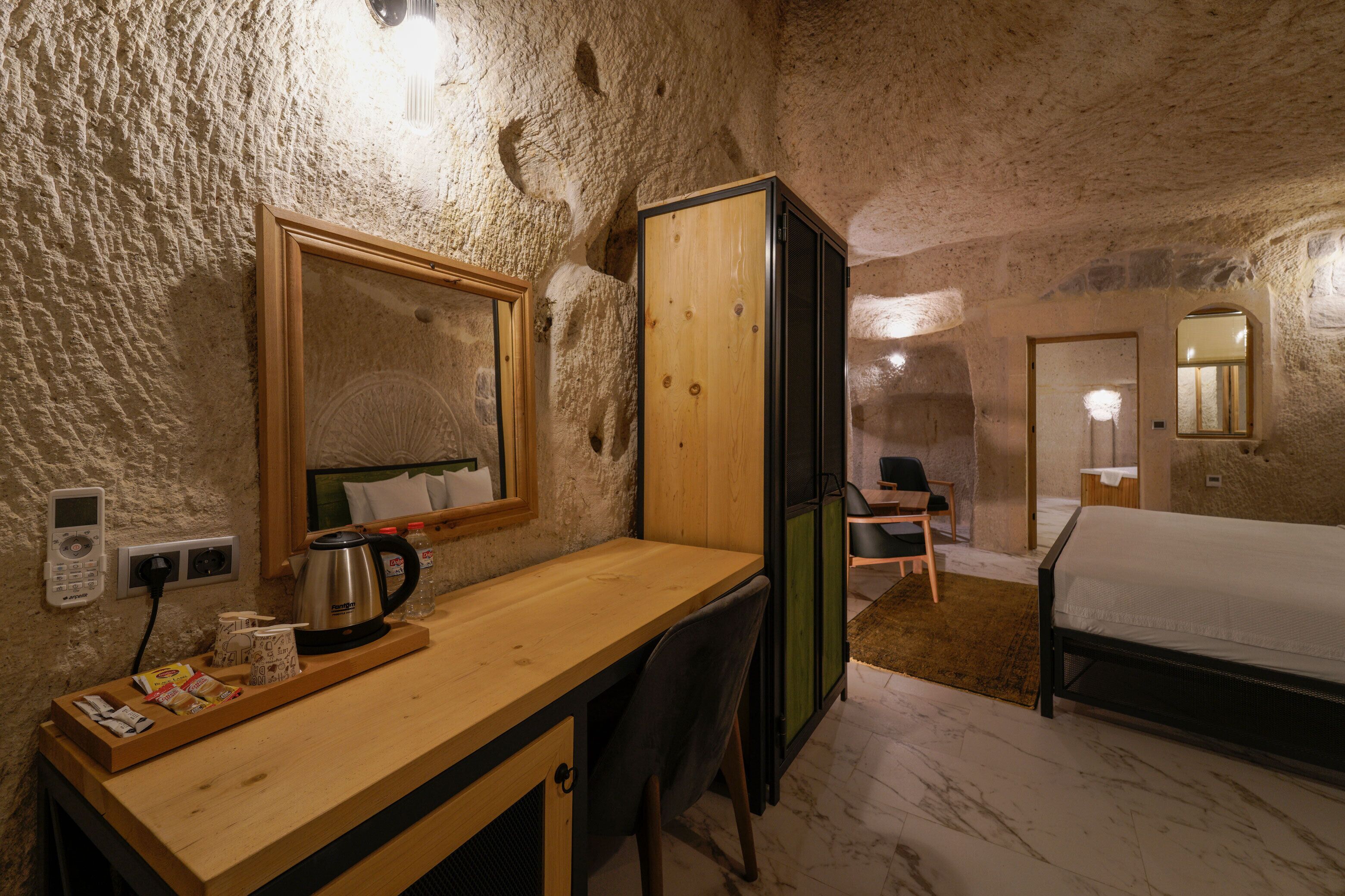 Een rustieke kamer met een houten bureau, een bed en een spiegel.