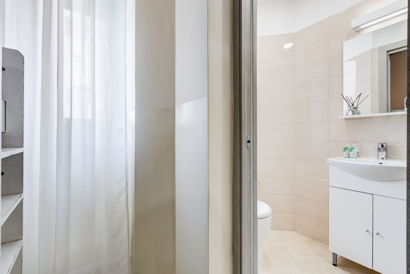 A modern bathroom with a toilet, a sink, and a mirror.