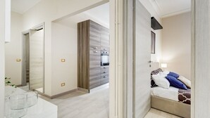 Una habitación de hotel moderna con cama, baño y kitchenette.