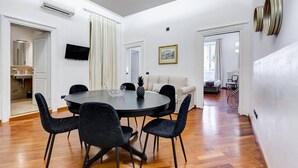 A modern interior with a dining area, a sofa, and a television.