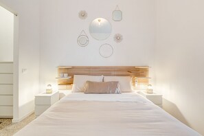 Camera da letto con un letto, comodini, una testiera e decorazioni a parete.