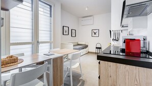 A compact kitchen with a dining area, a bed, and a small table with chairs. - BDC - The Left Loft in Trastevere (Roma)