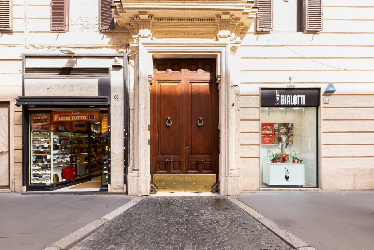 A street view with a shop entrance, a double wooden door, and a storefront with a glass display.