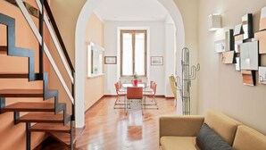 Un intérieur moderne avec un escalier, un coin repas et un canapé.