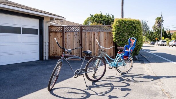 A residential garage with a wooden fence and a bicycle parked outside. - Pleasure Point Getaway with hot tub, dog friendly! (Santa Cruz)