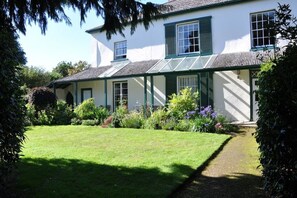 Enjoy a serene retreat amidst lush gardens and a sheltered porch.