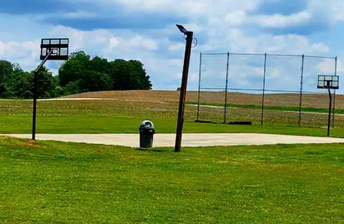 Un campo da basket con un cestino e una recinzione.