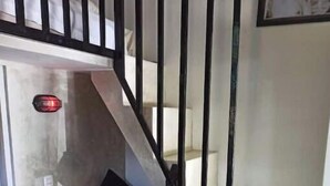 Un escalier avec un banc rembourré de couleur rouge et une petite table en bois au bas.