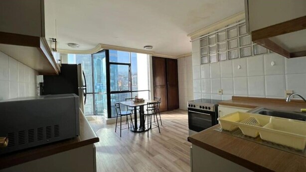 Una cocina moderna con comedor, ventanas amplias y vistas a la ciudad.