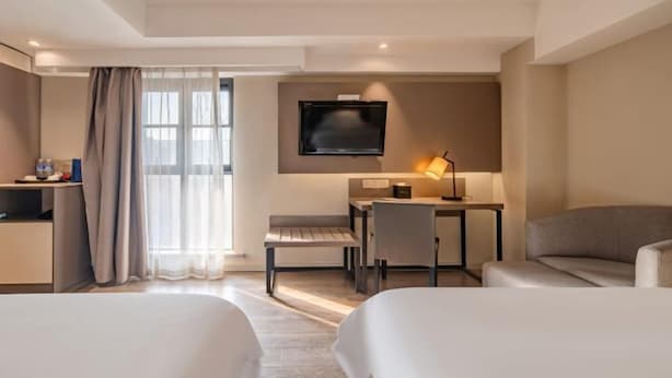 A hotel room with two beds, a desk with a chair, a TV mounted on the wall, and a lamp. - Ripple Hotel (Sihong Renmin Road) (Sihong)