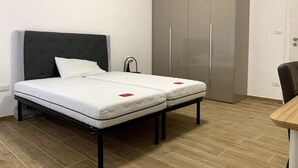 Une chambre à coucher avec un lit, une armoire et un bureau.
