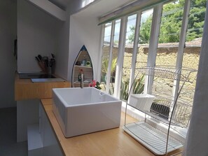 A modern bathroom with a large bathtub, a shower, and a window with a view of a garden. - Sages - Regency country villa in heart of Dolton (house and garden flat) (Dolton)