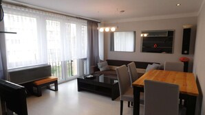 Ein modernes Wohnzimmer mit einer Couch, einem Couchtisch und einem Esstisch.