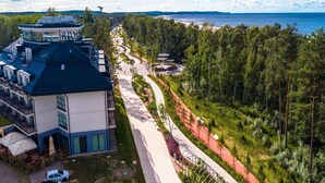 Ein modernes Hotel mit Dachterrasse, angelegtem Weg und Blick auf das Meer.