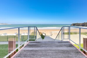 A wooden staircase leading to a beach with glass railings and a clear view of the ocean. - Ar Vro - Accès direct à la grande plage (Saint-Cast-le-Guildo)