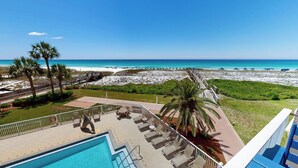 A pool area with lounge chairs, a wooden deck, and a view of the beach and ocean. - DOTG 304 - beautiful Gulf Front 2 BR with free beach service for 2 (Destin)