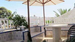 A covered outdoor seating area with patterned tiles, a table, and chairs. - Top of Villa - Sea View - Private Beach Hammamet 8056, Tunisia (Hammamet)