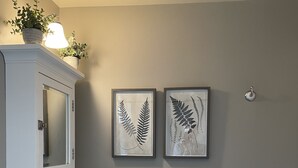 A bathroom with a white sink, a mirror, and two framed botanical prints on the wall. - Cozy, Romantic, Secluded, Cottage in the Heart of Cheyenne Cañon (Colorado Springs)