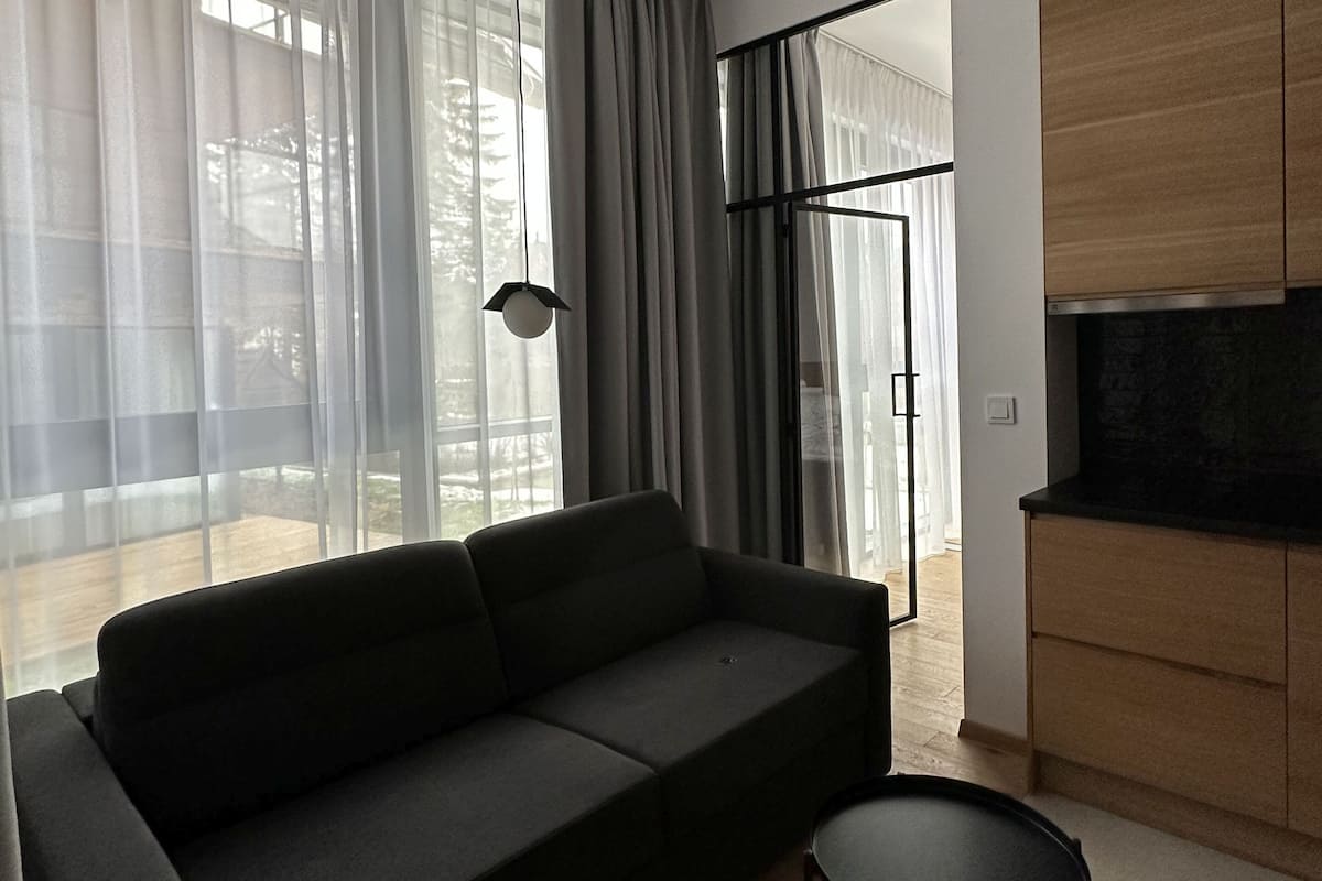 A modern living room with a sofa, a coffee table, and a TV cabinet.