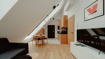 Een modern loftappartement met een eethoek, keuken en een grote televisie.