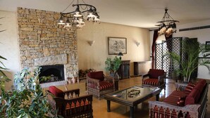 Un salon chaleureux avec une cheminée en pierre, des meubles en bois et un éclairage décoratif.