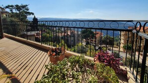 Un balcon offrant une vue sur le paysage urbain et les montagnes au loin.