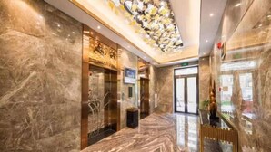 A marble-floored lobby with a modern elevator and a glass door entrance. - Kaibin International Hotel (Xining)