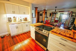 Enjoy cooking in this well-equipped kitchen with a central island, stainless steel stove, and oven, perfect for preparing meals.