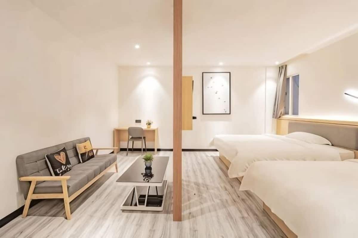 A hotel room with a bed, a sofa, a desk, and a chair.