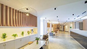 A modern interior with a long dining table, wooden slat wall, and potted plants. - Changee Hotel (Haikou Qilou Old Street Nanya Plaza) (Haikou)