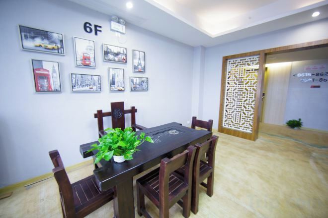 Un comedor con una mesa y sillas, un letrero con número en la pared y cuadros enmarcados.