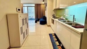 Cocina moderna con horno empotrado, un lavamanos y una ventana con vistas a un balcón.
