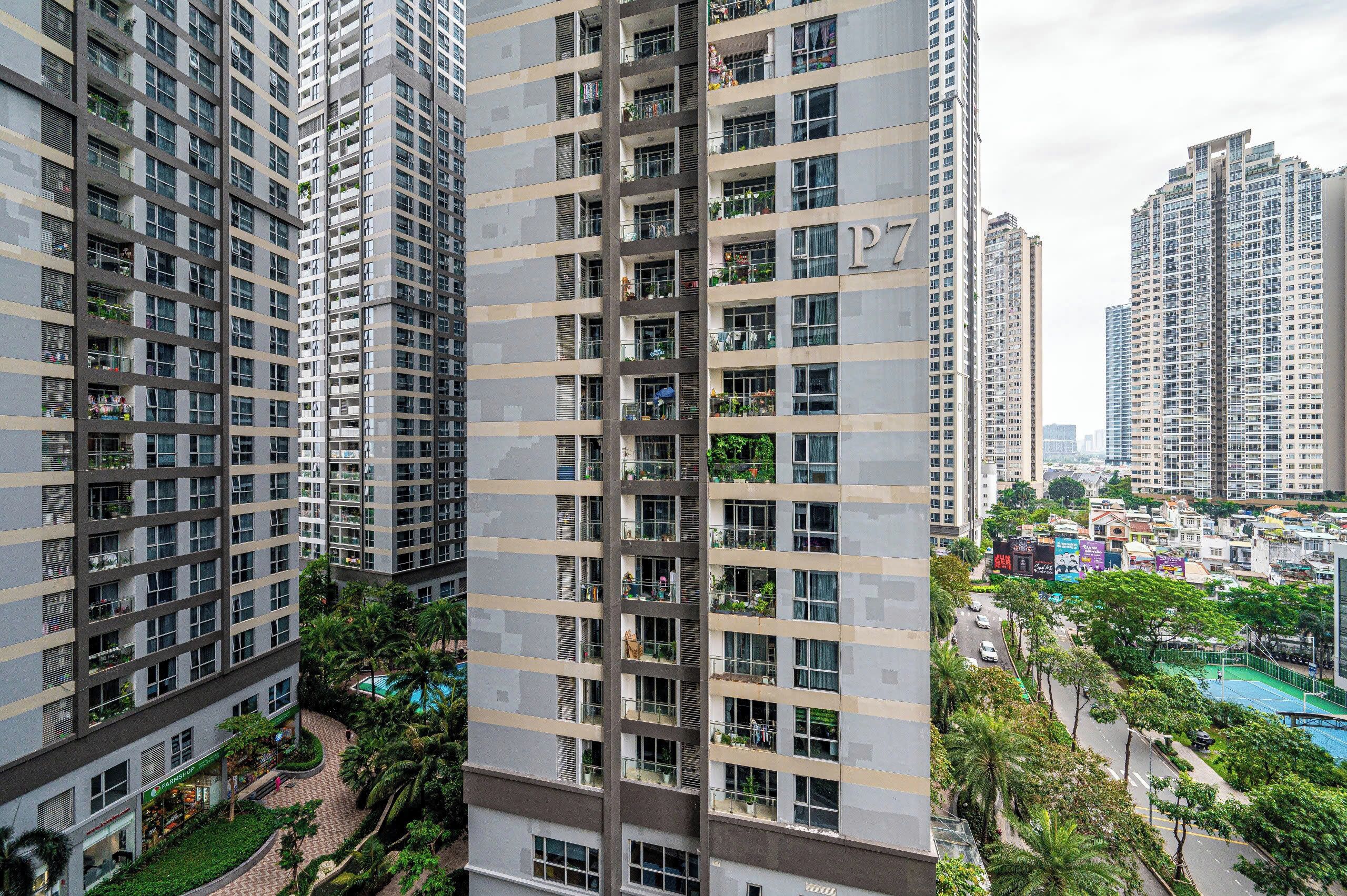 Un immeuble résidentiel de grande hauteur doté de nombreux balcons, d’une piscine et entouré d’un quartier urbain comprenant d’autres immeubles de grande hauteur.