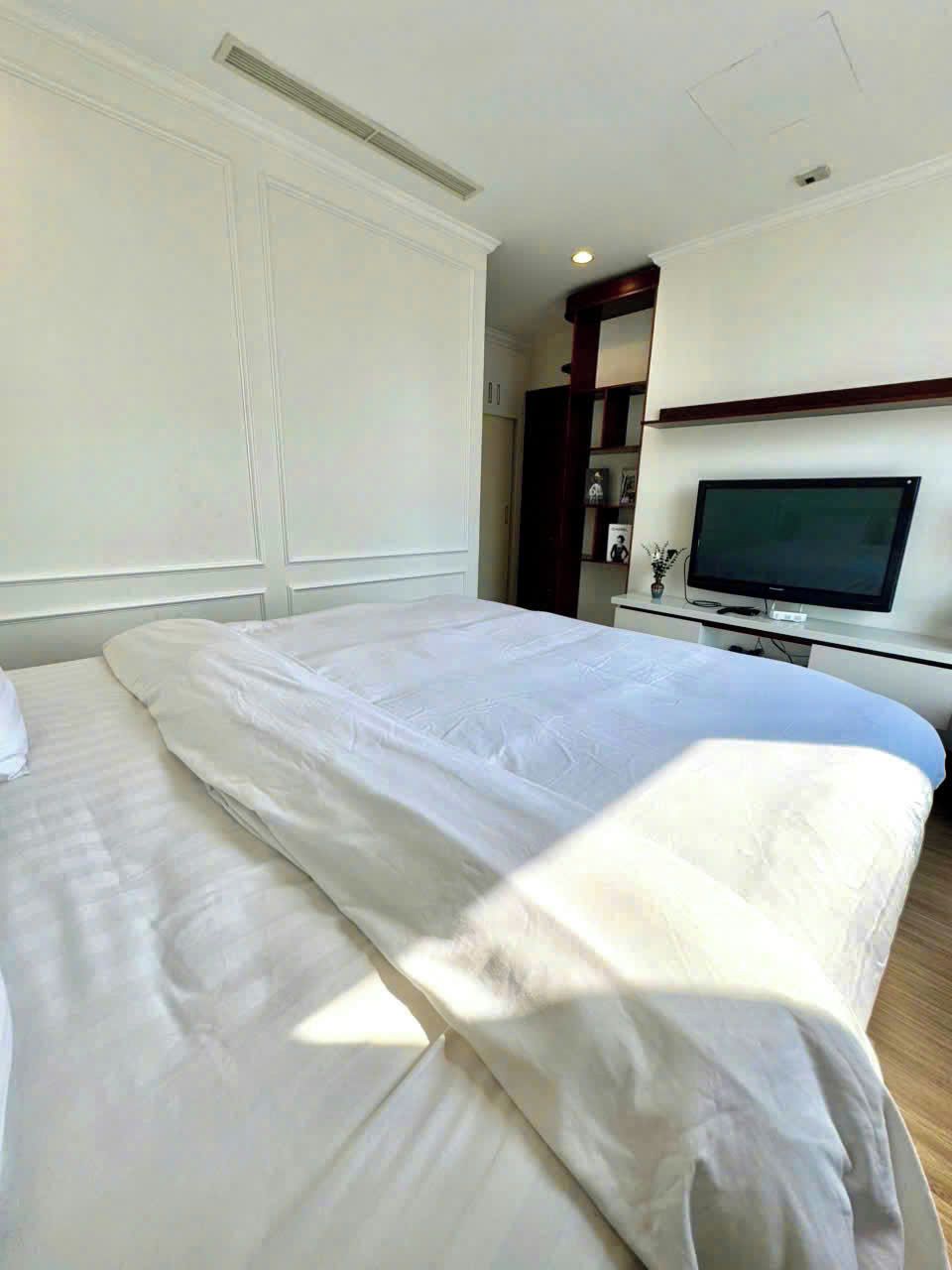 Ein Hotelzimmer mit einem großen Bett, einem Fernseher und einem Kleiderschrank.