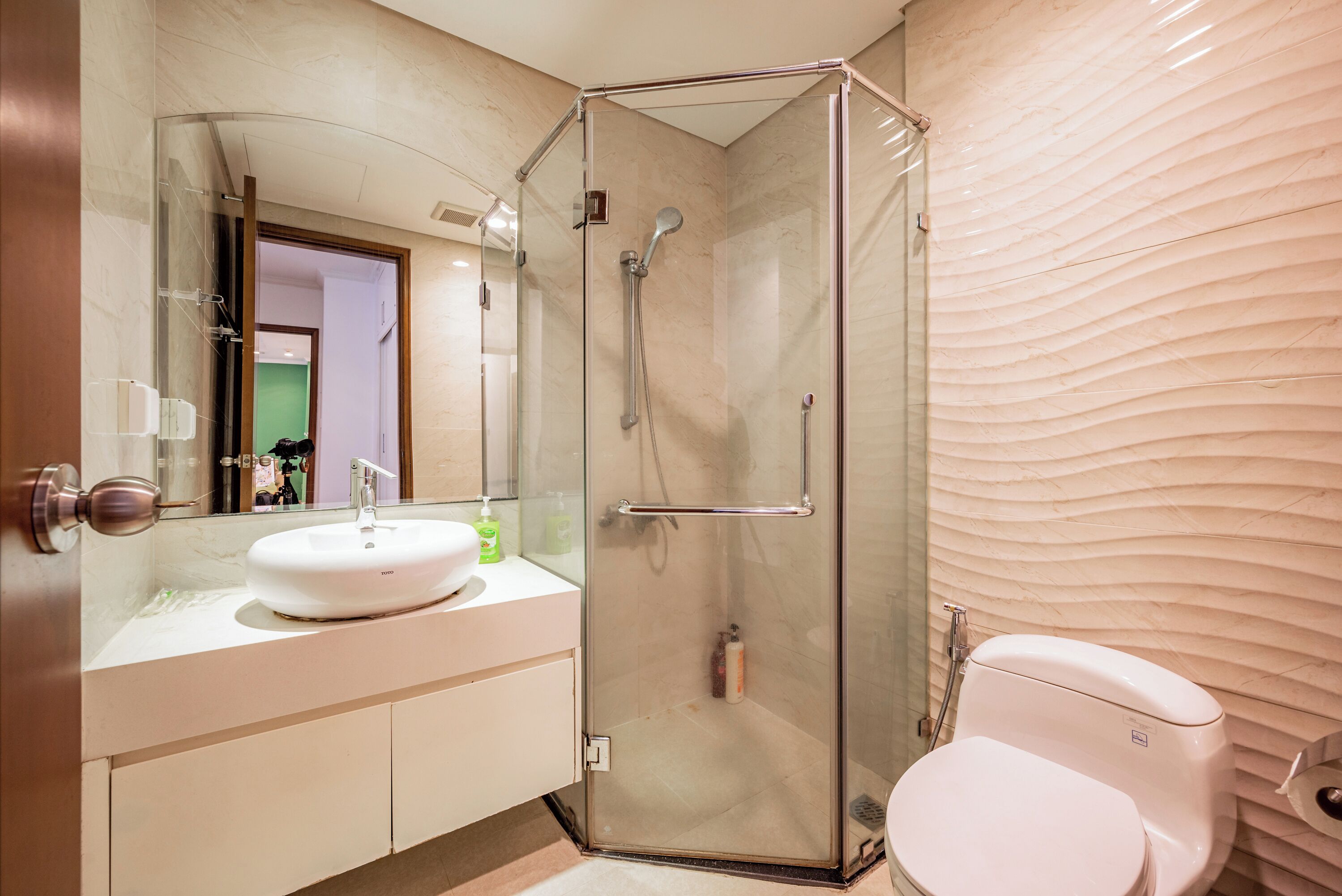Une salle de bain moderne avec une douche à parois de verre, un lavabo blanc et des toilettes.