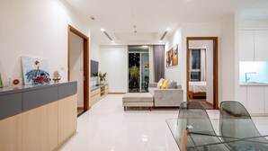 Una sala de estar moderna con una mesa de vidrio, un sofá y un televisor.