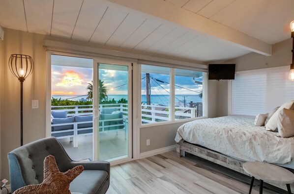 Relax in this serene bedroom with a large bed, flat-screen TV, and balcony views.